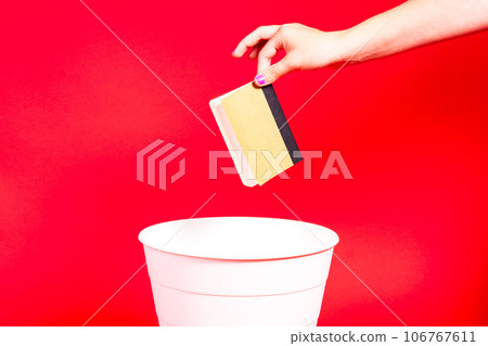 Throw notepad, notebook or diary into trash bin, notepad in hand in front of trash can Throw notepad, notebook or diary into trash bin, notepad in hand in front of trash can 106767611