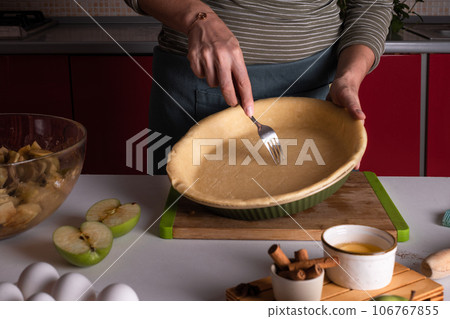 Authentic female hands making a base for a shortcrust pie, pie crust recipe 106767855