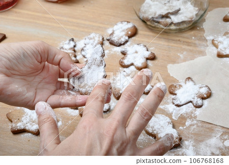 Women's hands in the process of preparing cookies in the home kitchen for the winter holidays. 106768168