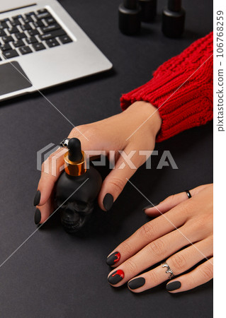 Womans hands with trendy bloody halloween manicure. Fashion jewelry and accessories shopping sale Womans hands with trendy bloody halloween manicure. Fashion jewelry and accessories shopping sale 106768259