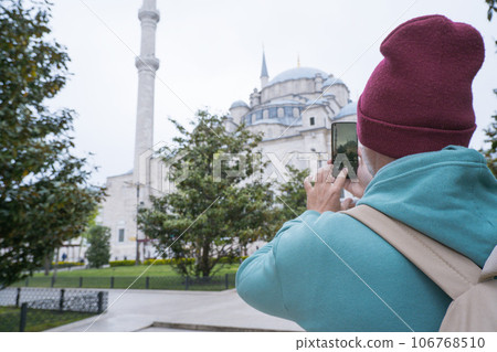 A male tourist takes a photo of the Fatih Mosque in Istanbul, Turkey as a keepsake A male tourist takes a photo of the Fatih Mosque in Istanbul, Turkey as a keepsake 106768510