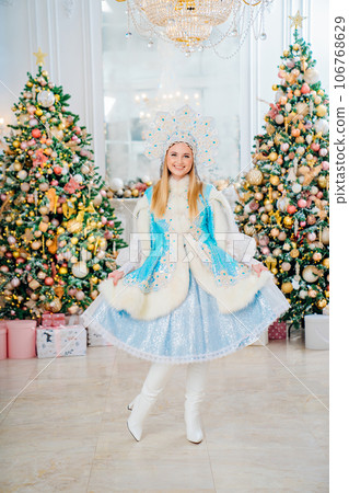 Snow Maiden in costume with short skirt and kokoshnik. room with christmas tree. 106768629