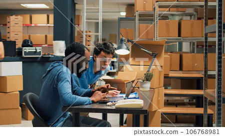 Business owners doing quality control on products from warehouse, checking cardboard packages of merchandise. Young entrepreneurs preparing goods in boxes, shipping distribution orders. Business owners doing quality control on products from warehouse, checking cardboard packages of merchandise. Young entrepreneurs preparing goods in boxes, shipping distribution orders. 106768981