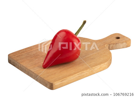 A pod of hot red pepper on a cutting board over a white background. 106769216