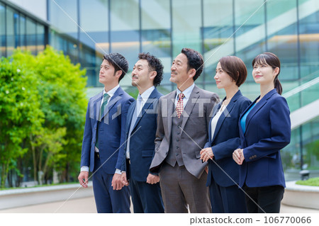 Business person looking up at the sky in front of an office building Business person looking up at the sky in front of an office building 106770066