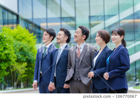 Business person looking up at the sky in front of an office building Business person looking up at the sky in front of an office building 106770067