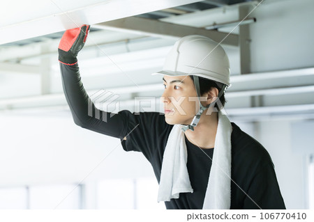 Young male worker wearing a helmet at a construction site Young male worker wearing a helmet at a construction site 106770410