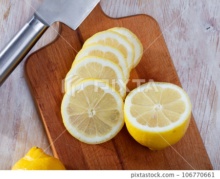 Sliced lemons on wooden table Sliced lemons on wooden table 106770661