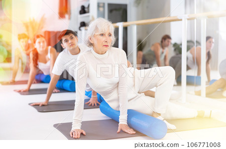 Group of different people doing exercises with roller Group of different people doing exercises with roller 106771008