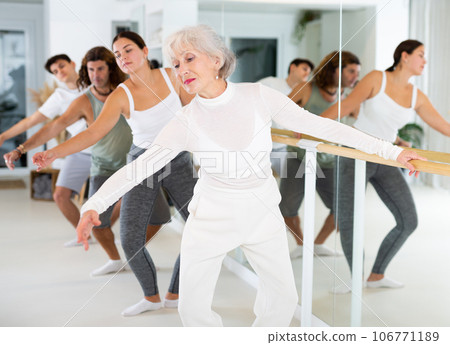Elderly woman doing choreography at ballet barre 106771189