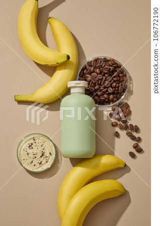 Cosmetic bottle without label decorated with roasted coffee beans and some fresh bananas. Banana (Musaceae) is a blossoming ingredient in beauty Cosmetic bottle without label decorated with roasted coffee beans and some fresh bananas. Banana (Musaceae) is a blossoming ingredient in beauty 106772190