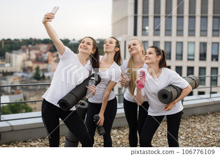 Yoginis taking self-photo on mobile after outdoor exercises 106776109