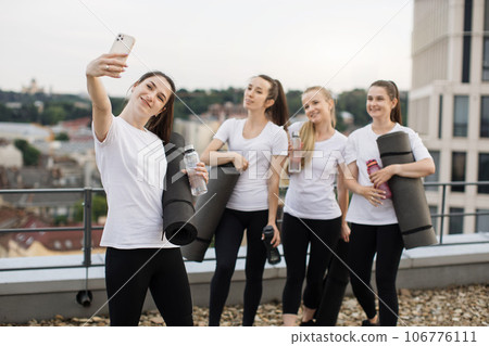 Yoginis taking self-photo on mobile after outdoor exercises 106776111