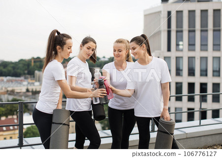 People putting water bottles together after yoga session 106776127