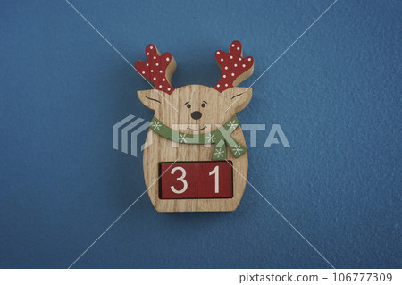 Festive wooden deer Viva Magenta cubes 31 blue background close-up top view. Christmas concept date or time Festive wooden deer Viva Magenta cubes 31 blue background close-up top view. Christmas concept date or time 106777309