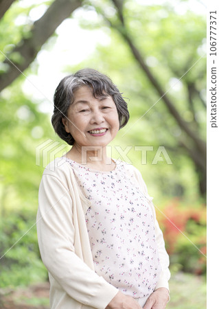 Senior woman taking a walk in the park 106777371