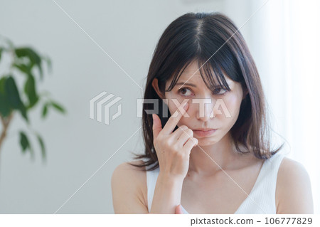 A woman worried about her face and eyes A woman worried about her face and eyes 106777829