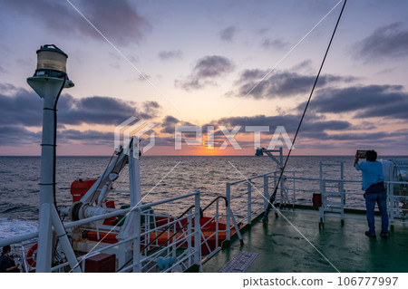 遊客在船的甲板上觀看日落並按下相機快門 106777997