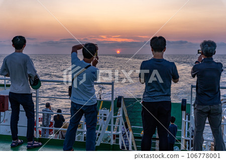 遊客在船的甲板上觀看日落並按下相機快門 106778001