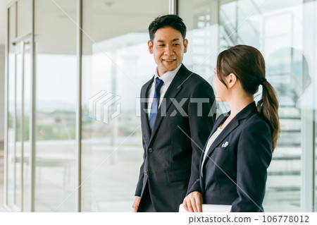 Businessman and businesswoman talking at work Businessman and businesswoman talking at work 106778012