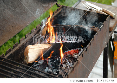 Grill with burning log and fork and knife for steak 106779276
