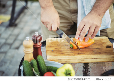 Unrecognizable man peeling sweet paprika with knife 106779282