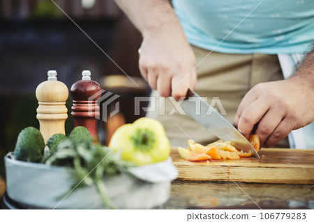 Unrecognizable man slicing sweet bell pepper for salad 106779283