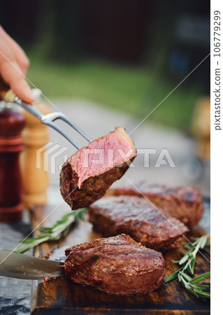 Piece of grilled strip steak on the fork 106779299