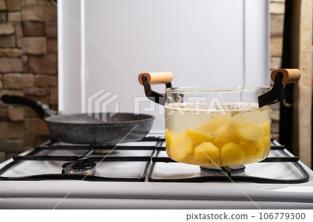 Boiling potato in transparent glass pot Boiling potato in transparent glass pot 106779300