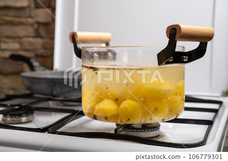 Boiling potato with seasoning in transparent glass pot Boiling potato with seasoning in transparent glass pot 106779301