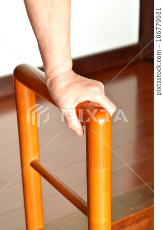 Senior woman's hand holding the entrance railing Senior woman's hand holding the entrance railing 106779981