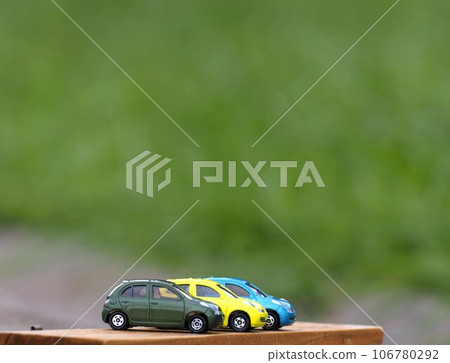 Landscape with minicars: Colorful march with green background 106780292