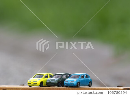 Landscape with minicars: Colorful march with green background 106780294