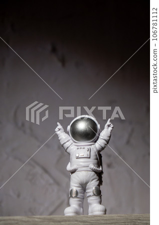 Plastic toy figure astronaut on moon concrete background Copy space. Concept of out of earth travel, private spaceman commercial flights missions and Sustainability 106781112