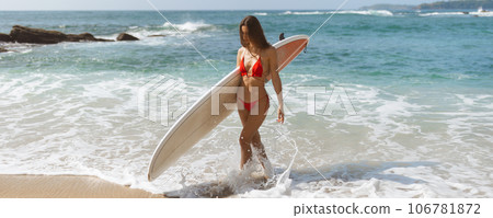 Enjoying the Sun and Surf: Young Woman Embracing Adventure on a Tropical Beach Enjoying the Sun and Surf: Young Woman Embracing Adventure on a Tropical Beach 106781872
