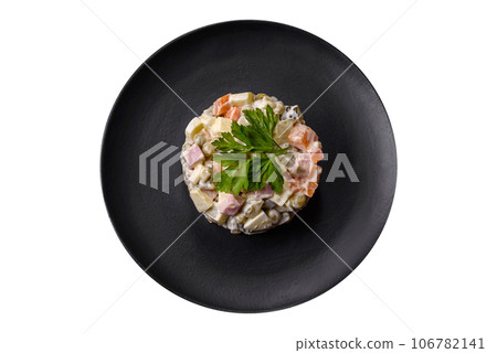 Delicious fresh Olivier salad with sausage, egg, cucumber, green peas, carrots and mayonnaise Delicious fresh Olivier salad with sausage, egg, cucumber, green peas, carrots and mayonnaise 106782141
