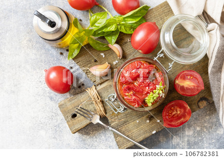 Healthy homemade fermented food. Sun-dried tomatoes in jar with spices and herbs. Home economics, autumn harvest preservation. Healthy homemade fermented food. Sun-dried tomatoes in jar with spices and herbs. Home economics, autumn harvest preservation. 106782381