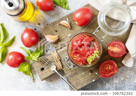 Healthy homemade fermented food. Sun-dried tomatoes in jar with spices and herbs. Home economics, autumn harvest preservation. Healthy homemade fermented food. Sun-dried tomatoes in jar with spices and herbs. Home economics, autumn harvest preservation. 106782382