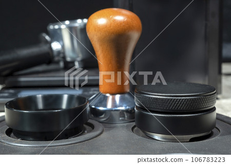 Close-up view of coffee tamper and portafilter 106783223