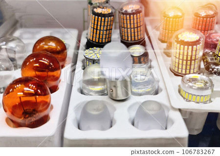Assorted LED car lamps and incandescent car lamp lie on the shelf of an auto store 106783267
