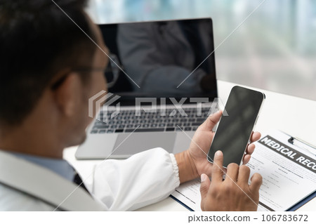 Doctor Smiling working with mobile phones and remote online services at the clinic smart medical doctor high quality service concept 106783672