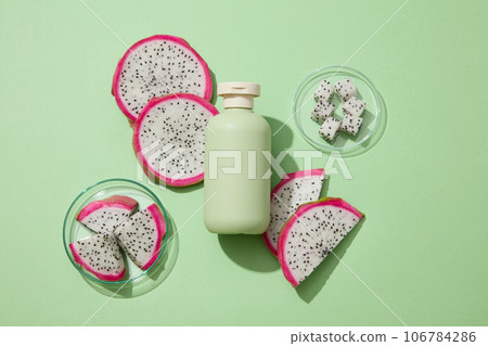 Concept of organic fruit with dragon fruit slices on petri dishes. Beauty container in green color featured. Dragon fruit (Hylocereus) is amazing for acne-prone skin 106784286