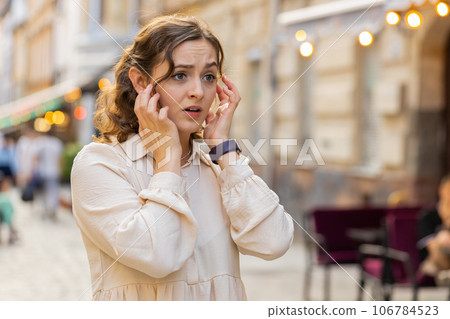 Sad unhappy frustrated young woman walking alone in city street, feeling bad, annoyed, grief problem 106784523