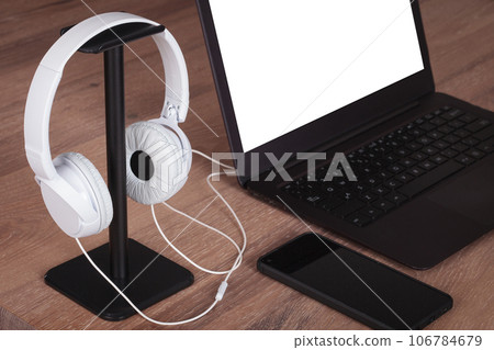 Modern Office Desk with Laptop and White Headphones, blank screen. Modern Office Desk with Laptop and White Headphones, blank screen. 106784679