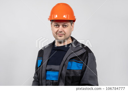 A young man construction worker in a safety helmet and work uniform on a white background 106784777