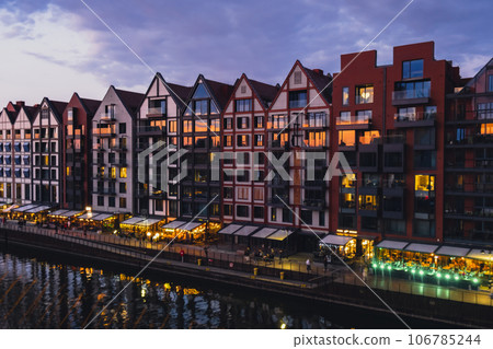 Old town in Gdansk at summer dusk Poland. Sunset night view from the window rooftop on new modern architecture buildings Hotels to stay in Gdansk Place to eat over Motlawa river Wyspa Spichrzow Old town in Gdansk at summer dusk Poland. Sunset night view from the window rooftop on new modern architecture buildings Hotels to stay in Gdansk Place to eat over Motlawa river Wyspa Spichrzow 106785244