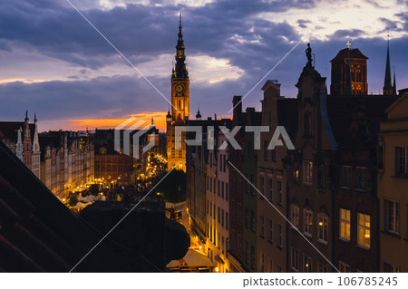 Beautiful old town in Gdansk at summer dusk Poland. Sunset night view from the window rooftop on historical centre Dluga street and city hall architecture buildings St Mary Basilica. Travel attraction Beautiful old town in Gdansk at summer dusk Poland. Sunset night view from the window rooftop on historical centre Dluga street and city hall architecture buildings St Mary Basilica. Travel attraction 106785245
