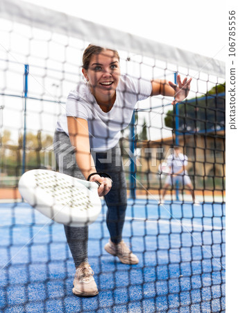 Young fit woman playing paddle tennis outdoors Young fit woman playing paddle tennis outdoors 106785556