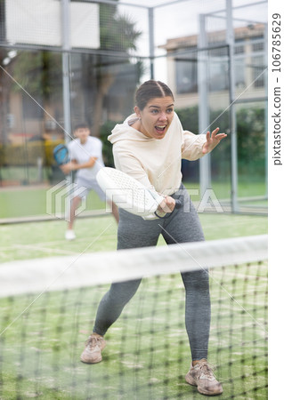 Young female paddle tennis player performing forehand 106785629