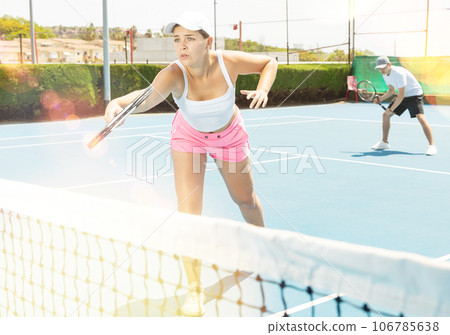 Portrait of young beautiful female tennis player about to serve ball. 106785638